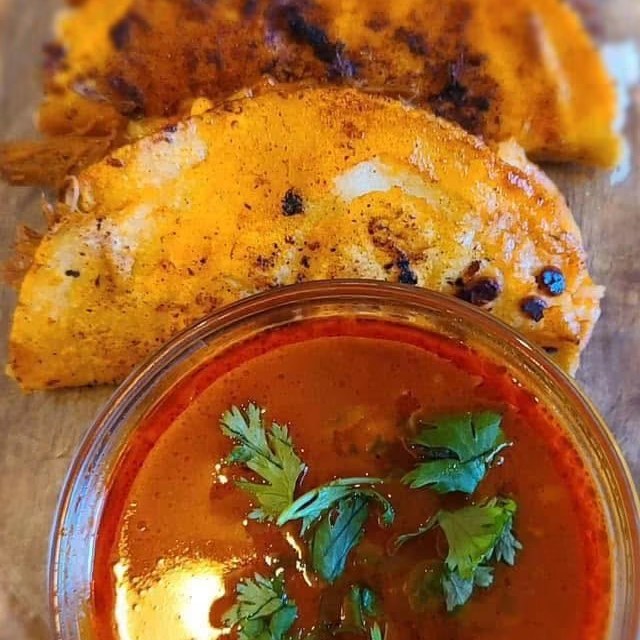Quesabirrias with a cup of beef consommé for dipping